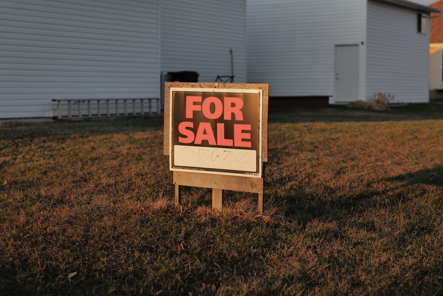 Modern house with a For Sale sign in a sunny suburban neighborhood, highlighting an available property.